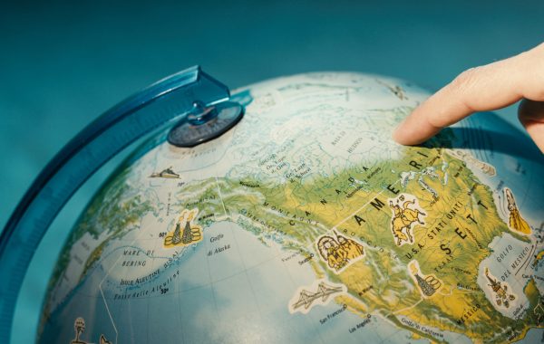 Close up of finger pointing on globe.